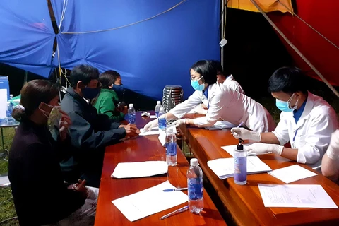Sinh viên tình nguyện hướng dẫn người dân khai báo y tế tại chốt kiểm soát y tế thị xã Hương Trà. (Ảnh: Tường Vi/TTXVN)