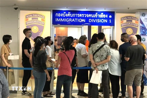 Nhiều người nước ngoài xếp hàng bên ngoài văn phòng Cục Di trú Thái Lan ở Bangkok để xin gia hạn thị thực nhập cảnh ngày 23/3. (Ảnh: Ngọc Quang/TTXVN)