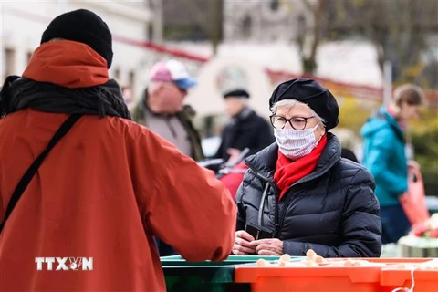 Người dân đeo khẩu trang để phòng tránh lây nhiễm COVID-19 khi mua sắm tại chợ ở Leipzig, Đức ngày 4/4/2020. (Ảnh: THX/ TTXVN)