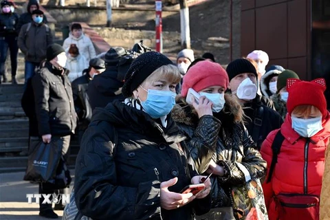 Người dân đeo khẩu trang phòng lây nhiễm COVID-19 tại Kiev, Ukraine, ngày 23/3/2020. (Ảnh: AFP/TTXVN)