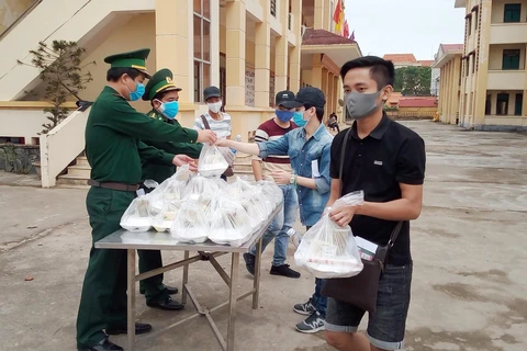 Những suất cơm được cán bộ chiến sỹ biên phòng Quảng Bình chuẩn bị tươm tất, chu đáo để trao cho công dân ăn trước khi lên xe về nhà. (Ảnh: Võ Dung -TTXVN)