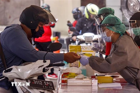 Nhân viên y tế lấy mẫu xét nghiệm COVID-19 tại Jakarta, Indonesia, ngày 8/4/2020. (Ảnh: AFP/TTXVN)