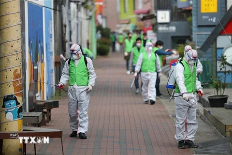 Nhân viên y tế phun khử trùng đường phố nhằm ngăn chặn sự lây lan của dịch COVID-19 tại Daegu, Hàn Quốc ngày 11/4/2020. (Ảnh: Yonhap/TTXVN)