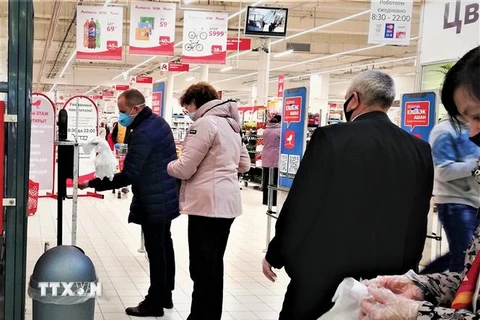Người dân thủ đô Moskva (Nga) tuân thủ khoảng cách xã hội 2m, xếp hàng đeo găng tay và khử trùng trước khi vào mua hàng. (Ảnh: Duy Trinh/TTXVN)
