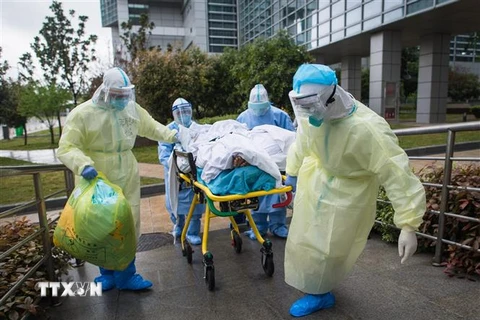 Nhân viên y tế chuyển bệnh nhân nhiễm COVID-19 tới bệnh viện ở Vũ Hán,tỉnh Hồ Bắc, Trung Quốc, ngày 29/3/2020. (Ảnh: THX/TTXVN)