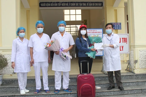 Giám đốc Bệnh viện Đa khoa huyện Nho Quan tặng hoa cho bệnh nhân 229 trong ngày xuất viện. (Ảnh: Thùy Dung/TTXVN)