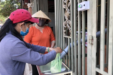Người dân đến lấy gạo miễn phí tại cây ATM gạo nghĩa tình ở thành phố Long Khánh, Đồng Nai. (Ảnh: Lê Xuân/TTXVN)