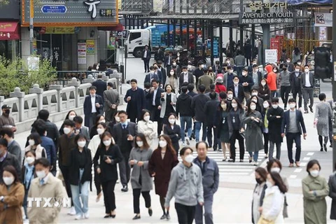 Người dân đeo khẩu trang khi di chuyển trên đường phố Seoul, Hàn Quốc ngày 20/4/2020. (Ảnh: Yonhap/ TTXVN)