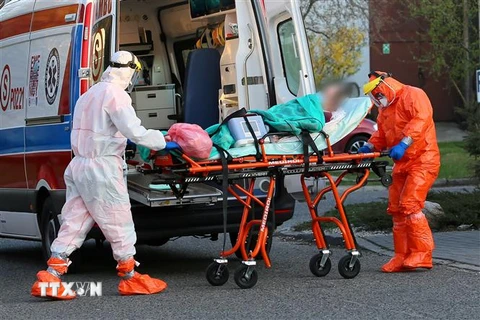 Nhân viên y tế chuyển bệnh nhân mắc COVID-19 vào bệnh viện ở Wolica, Ba Lan ngày 20/4/2020. (Ảnh: PAP/TTXVN)
