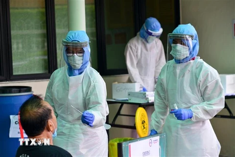 Nhân viên y tế lấy mẫu dịch xét nghiệm COVID-19 cho người dân tại bệnh viện ở Damansara, Malaysia ngày 30/3/2020. (Ảnh: THX/ TTXVN)