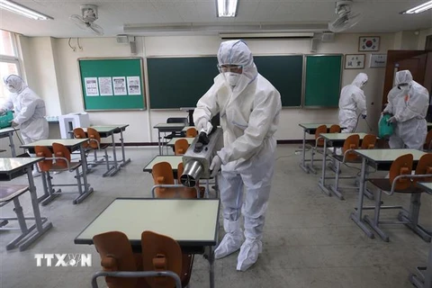 Nhân viên kiểm dịch phun thuốc khử trùng tại trường học ở Seoul, Hàn Quốc ngày 11/5/2020 nhằm ngăn chặn sự lây lan của COVID-19. (Ảnh: Yonhap/TTXVN)