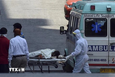  Nhân viên y tế chuyển bệnh nhân nghi mắc COVID-19 từ xe cứu thương vào một bệnh viện ở New Delhi, Ấn Độ ngày 27/4/2020. (Ảnh: AFP/TTXVN)
