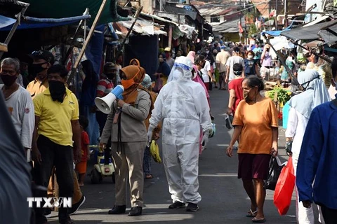 Nhân viên y tế kêu gọi người dân xét nghiệm COVID-19 tại một khu chợ ở Jakarta, Indonesia ngày 2/6/2020. (Ảnh: THX/ TTXVN)
