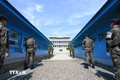 Binh sỹ Hàn Quốc (phía trước) và binh sỹ Triều Tiên (phía sau) gác tại đường giới tuyến phi quân sự giữa hai miền Triều Tiên ở Panmunjom ngày 26/4/2018. (Ảnh: AFP/ TTXVN)