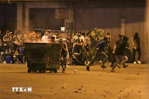 Người biểu tình xung đột với cảnh sát trong cuộc biểu tình tại Tripoli, Liban, ngày 12/6/2020. (Ảnh: AFP/TTXVN)