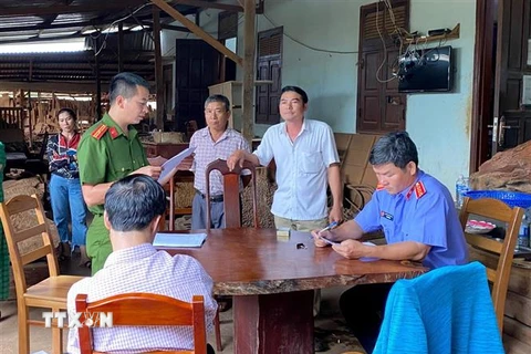 Cơ quan Cảnh sát điều tra đọc quyết định bắt Nguyễn Quốc Hùng (thứ 2 bên phải mặc áo trắng). )Ảnh: Quang Thái/TTXVN)
