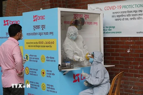 Nhân viên y tế lấy mẫu dịch xét nghiệm COVID-19 cho người dân tại bệnh viện ở Dhaka, Bangladesh, ngày 3/5/2020. (Ảnh: THX/TTXVN)