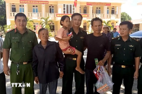 Lực lượng chức năng tỉnh Quảng Bình trao cháu Dương Thị Diễm Quỳnh cho gia đình. (Ảnh: Văn Tý/TTXVN)
