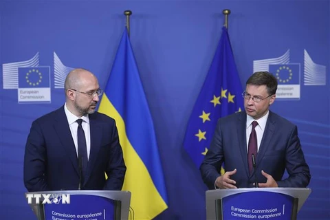 Thủ tướng Ukraine Denys Shmyhal (trái) và Ủy viên châu Âu phụ trách kinh tế Valdis Dombrovskis sau khi ký thỏa thuận hỗ trợ tài chính vĩ mô ở Brussels, Bỉ ngày 23/7/2020. (Ảnh: AFP/TTXVN)