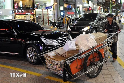 Người dân làm việc trên đường phố tại Busan, Hàn Quốc. (Ảnh: AFP/ TTXVN)