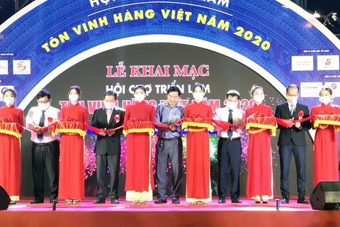 Các đại biểu cắt băng khai mạc Hội chợ Triển lãm Tôn vinh hàng Việt - năm 2020. (Ảnh: Mỹ Phương/TTXVN)