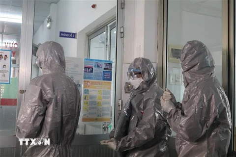 Các bác sỹ Bệnh viện Chợ Rẫy Thành phố Hồ Chí Minh mặc trang phục bảo hộ trước khi vào khu vực cách ly bệnh nhân. (Ảnh: Đinh Hằng/TTXVN)