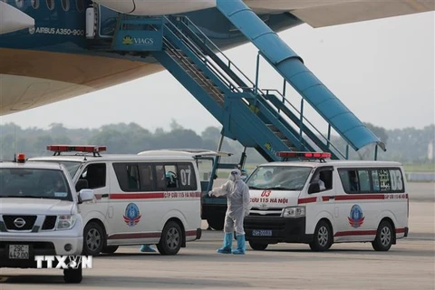 Sau khi xuống máy bay, các công dân được ôtô chuyên dùng đưa về cơ sở cách ly y tế. (Ảnh: Thành Đạt/TTXVN)