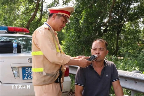 Lực lượng Cảnh sát giao thông tỉnh Bắc Ninh tiến hành kiểm tra nồng độ cồn trong người của người tham gia giao thông. (Ảnh: Thanh Thương/TTXVN)