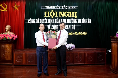 Ông Nguyễn Quốc Chung, Phó Bí thư Tỉnh ủy, Chủ tịch HĐND tỉnh Bắc Ninh (trái) trao Quyết định cho ông Tạ Đăng Đoan. (Ảnh: Thái Hùng/TTXVN)