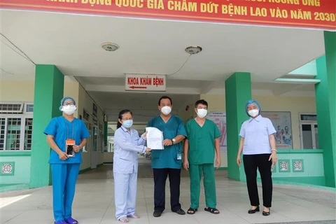 Đại diện lãnh đạo Bệnh viện Phổi Đà Nẵng trao giấy xuất viện cho bệnh nhân 445 mắc COVID-19. (Ảnh: Văn Dũng/TTXVN)