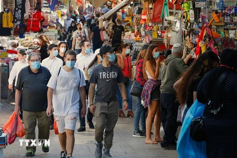 Người dân đeo khẩu trang phòng lây nhiễm COVID-19 tại một khu chợ ở Tel Aviv, Israel, ngày 7/5/2020. (Ảnh: AFP/ TTXVN)