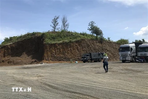 Khu đồi đất bị san ủi gần hết để lập bến bãi đỗ xe tải. (Ảnh: Phạm Cường/TTXVN)