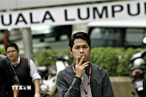 Người dân hút thuốc lá trên đường phố tại Kuala Lumpur, Malaysia. (Ảnh: AFP/ TTXVN)