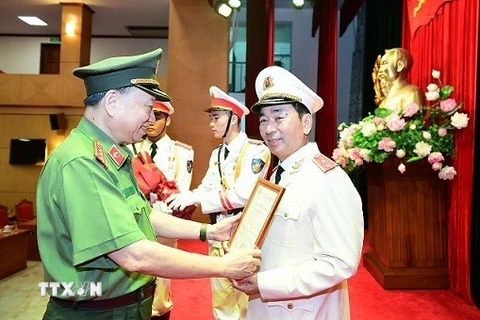 Bộ trưởng Bộ Công an Tô Lâm trao Quyết định của Chủ tịch nước thăng cấp bậc hàm từ Thiếu tướng lên Trung tướng đối với đồng chí Trần Quốc Tỏ, Thứ trưởng Bộ Công an. (Ảnh: TTXVN phát)