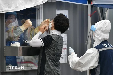 Nhân viên y tế lấy mẫu xét nghiệm COVID-19 cho người dân tại Seoul, Hàn Quốc ngày 26/8/2020. (Ảnh: AFP/TTXVN)