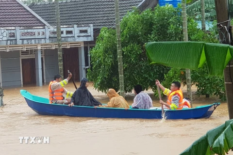 Di chuyển người dân ra khỏi khu vực ngập lũ tại huyện Cam Lộ. (Ảnh: Thanh Thủy/TTXVN)