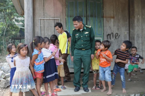 Cán bộ Đồn biên phòng Làng Mô cùng trẻ nhỏ thôn Trung Sơn, xã Trường Sơn, huyện Quảng Ninh (Quảng Bình). (Ảnh: Danh Lam/TTXVN)