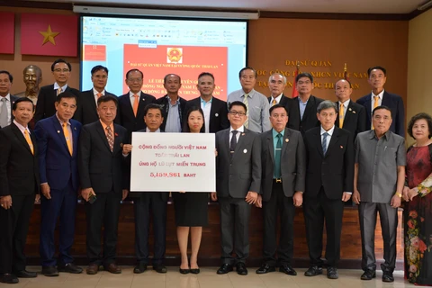 Đại diện Đại sứ Quán Việt Nam tiếp nhận quyên góp ủng hộ đồng bào miền Trung của cộng đồng người Việt tại Thái Lan. (Ảnh: Hữu Kiên/TTXVN)