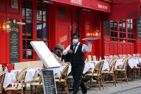 Nhân viên phục vụ thực khách tại một nhà hàng ở Paris, Pháp ngày 28/10/2020. (Ảnh: THX/TTXVN)