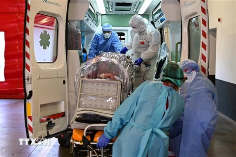 Nhân viên y tế chuyển bệnh nhân nhiễm COVID-19 tới bệnh viện ở Varese, Italy. (Ảnh: AFP/TTXVN)