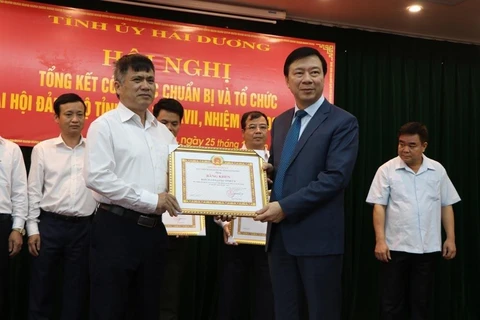 Bí thư Tỉnh ủy Hải Dương Phạm Xuân Thăng (phải) trao bằng khen tặng tập thể có thành tích xuất sắc trong tổ chức Đại hội Đảng bộ tỉnh lần thứ XVII nhiệm kỳ 2020-2025. (Ảnh: Mạnh Minh/TTXVN)