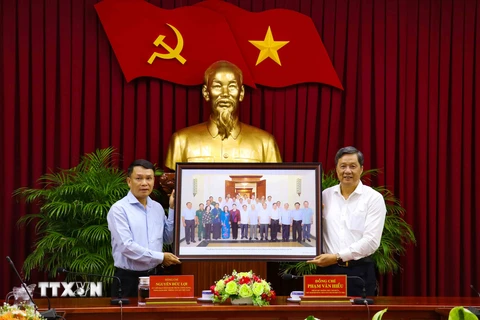 Tổng Giám đốc TTXVN Nguyễn Đức Lợi tặng bức ảnh lãnh đạo thành phố Cần Thơ tại buổi làm việc với Bộ Chính trị do phóng viên TTXVN chụp. (Ảnh: Ngọc Thiện/TTXVN)