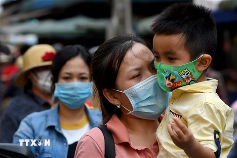 Người dân đeo khẩu trang phòng lây nhiễm COVID-19 tại Phnom Penh, Campuchia. (Ảnh: AFP/TTXVN)