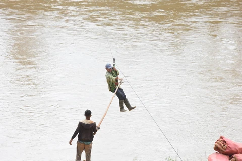Người dân liều mình đu dây qua sông Pô Kô. (Ảnh: Khoa Chương/TTXVN)