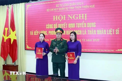 Thượng tá Ngô Nam Cường, Chỉ huy trưởng Bộ Chỉ huy Quân sự tỉnh Thừa Thiên-Huế trao quyết định tuyển dụng và trao quân hàm cho thân nhân liệt sỹ. (Ảnh: TTXVN phát)