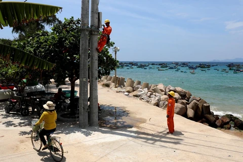EVN lắp đặt côngtơ cho khách hàng dùng điện trên đảo Nhơn Châu (Bình Định). (Ảnh: Ngọc Hà/TTXVN)