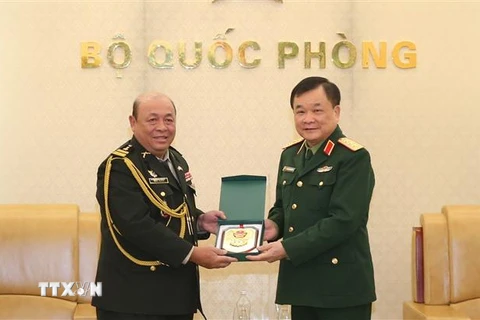 Thượng tướng Hoàng Xuân Chiến trao biểu tượng Bộ Quốc phòng Việt Nam tặng Đại tá Rem Kan, Tùy viên Quân sự Campuchia tại Việt Nam. (Ảnh: Hồng Pha/TTXVN phát)