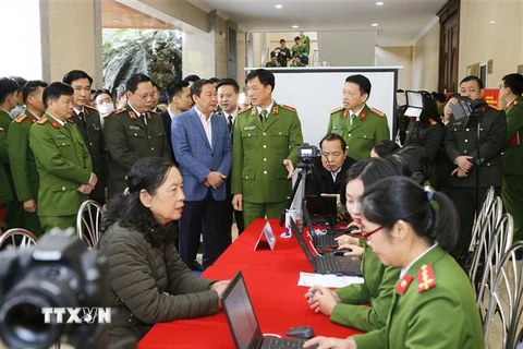 Thiếu tướng Nguyễn Duy Ngọc, Thứ trưởng Bộ Công an và các đại biểu thăm quan việc triển khai của các đơn vị công an quận cấp Căn cước công dân lưu động. (Ảnh: Doãn Tấn/TTXVN)