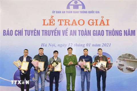 Thiếu tướng Nguyễn Duy Ngọc, Thứ trưởng Bộ Công an, Phó Chủ tịch Ủy ban An toàn giao thông Quốc gia trao giải Nhì cho các tác giả. (Ảnh: Doãn Tấn/TTXVN)
