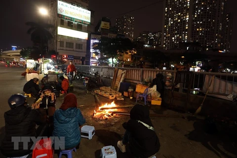 Người Hà Nội sưởi ấm bên đống lửa trên phố trong đêm giá lạnh. (Ảnh: Phan Tuấn Anh/TTXVN)